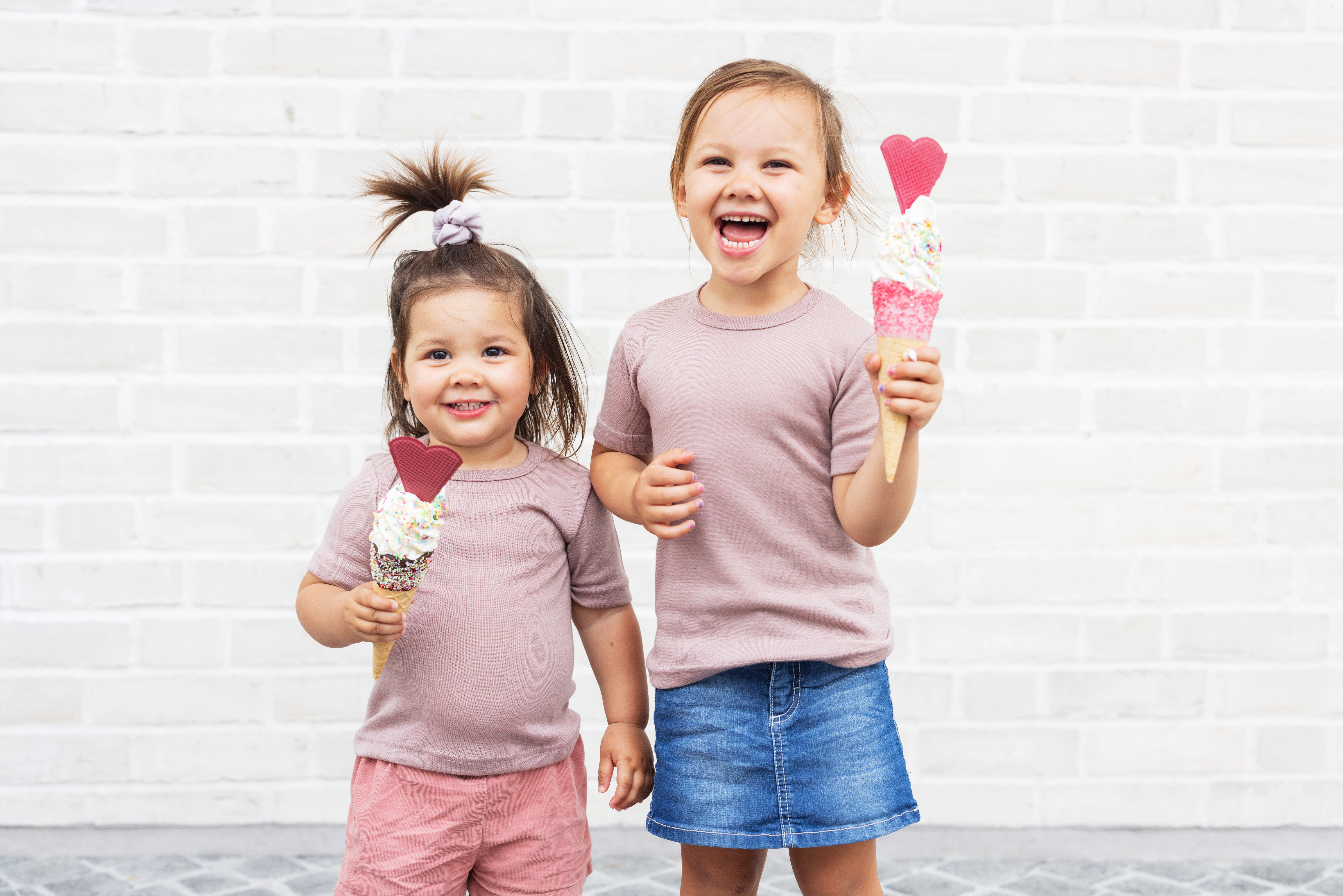 Zwei Kinder tragen leichte Wolle-Seide-Shirts von ENGEL und genießen Eiscreme